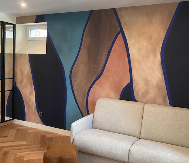 Panoramique mural motif abstrait style moderne installé dans un espace intérieur, réalisé par Marchand Décoration Château-Gontier.